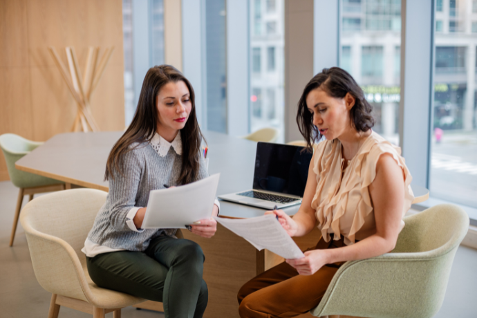 Two women working on laptops in an office