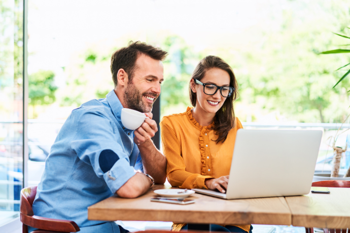 Couple working through their finances at a laptop