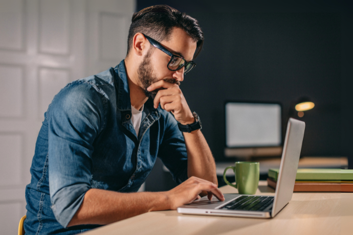 Man thinking while working at a laptop