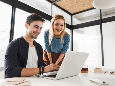 Couple smiling at a laptop together